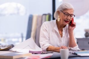 oudere dame aan de telefoon op werk